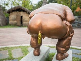 Shitting monument with golden poop.